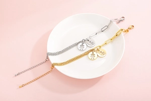 Dettaglio di braccialetti in acciaio inossidabile oro e argento con ciondolo a forma di ragazza