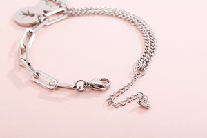 Dettaglio del bracciale asimmetrico in acciaio al titanio con pendente rotondo
