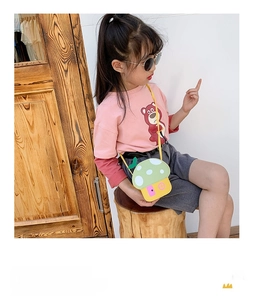 Outdoor shot of a girl wearing a yellow mushroom house shoulder bag with polka dot pattern