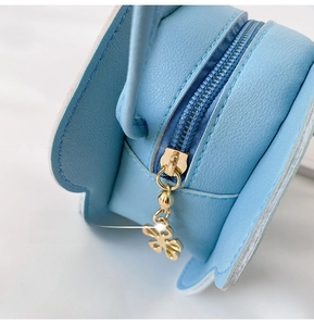Detailed view of the light blue mini bag zipper with a gold butterfly metal puller