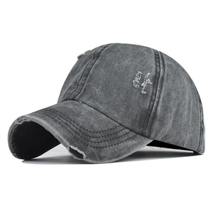 Detailed macro view of distressed dark grey washed cotton baseball cap with torn fabric