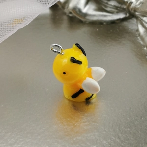 Close-up of yellow resin bee pendant with metal ring for DIY jewelry making