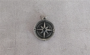 Detail of vintage compass pendant in oxidized silver steel with black bead and NSEW engraving