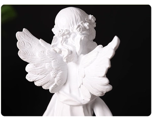 Close-up of angel sculpture wings and flower hair accessories with detailed resin texture