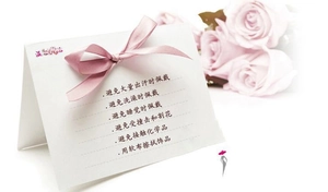 Close-up of a pink ribbon bow with a jewelry care guide card on a white background
