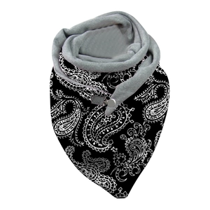 Detail of black paisley patterned scarf with grey plush lining and button closure