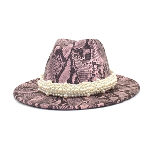 Close-up of pink and black snake print fedora hat with elegant faux pearl embellishments