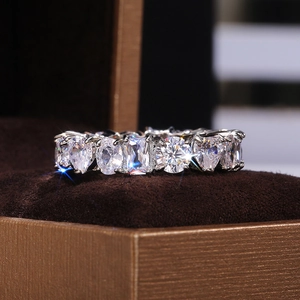 Macro shot of silver ring with heart and emerald cut cubic zirconia stones on velvet box