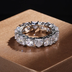 Close-up of eternity ring with heart and rectangle zircons on brushed metal stand
