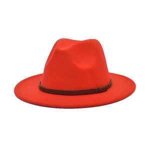 Detail of red wool felt fedora featuring a brown leather band with wave texture