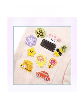Detail of colorful embroidered patches including stars and fruit on a canvas bag