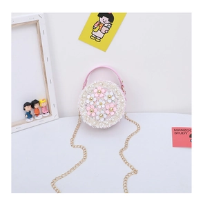 Detail of child circular handbag with 3D leather flowers, pearls and golden chain