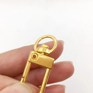 Premium gold plated swivel lobster clasp for DIY bags and keychains held by fingers