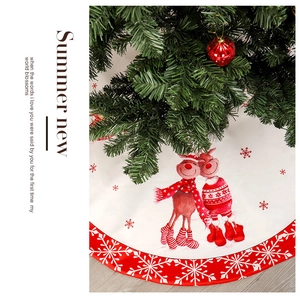 Detailed view of white Christmas tree skirt with festive reindeer and snowflake patterns