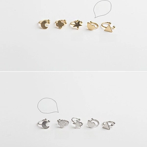 Detail of star, heart, and moon ear cuff set in gold and silver finishes