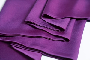 Detailed macro view of purple faux silk scarf fabric showing smooth satin texture and shine