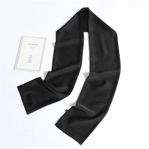 Close-up of a black silk-like narrow scarf showing smooth texture and rolled edges