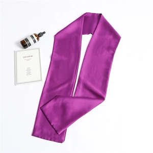 Detailed view of soft purple silk scarf with smooth texture on a clean white surface