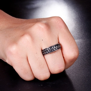 Close-up of vintage silver braided titanium steel ring on male hand with aged texture