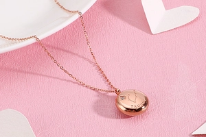 Detail of rose gold Taurus zodiac necklace with sparkling diamond on pink background