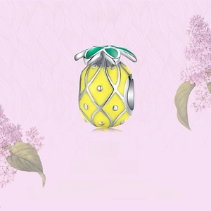 Close-up of S925 sterling silver pineapple charm with yellow enamel on floral background