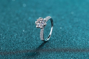 Macro detail of six-prong S925 silver ring featuring 1ct Moissanite on blue glitter