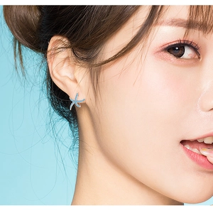 Detail of s925 silver starfish stud earring with sparkling blue crystals on model ear