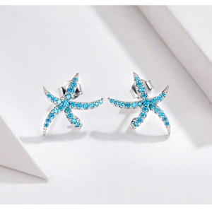Macro shot of S925 sterling silver starfish stud earrings with sky blue gemstones