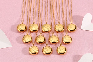 Flat lay of twelve gold zodiac necklaces with star maps and small cubic zirconia stones