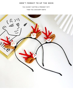 Detail of Christmas headband with red reindeer antlers and 3D Santa Claus ornament
