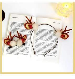 Christmas reindeer antlers headband with brown felt ears and red berry details on a book