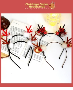 Detail of Christmas reindeer antler headbands with red berries and white pompoms on a book