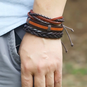 Dettaglio del bracciale multistrato in pelle intrecciata marrone e arancione regolabile