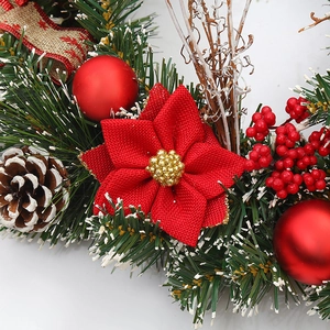 Christmas wreath with red fabric flowers, pine cones and berries for festive decoration