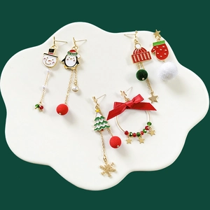 Christmas themed earrings set featuring snowman, penguin, and tree icons on white cloud base