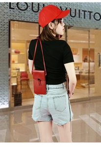 Detail of red PU leather touchscreen phone bag with tassel and adjustable strap
