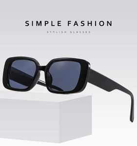 Detail shot of black square frame sunglasses on a white pedestal with stylish text