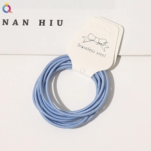 Detail of light blue high-elasticity hair ties bundled on a branded white card