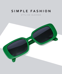 Detail of trendy green rectangular sunglasses with thick frames and dark grey lenses