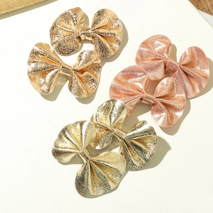 Three metallic faux leather bow hair clips in champagne gold and rose gold colors