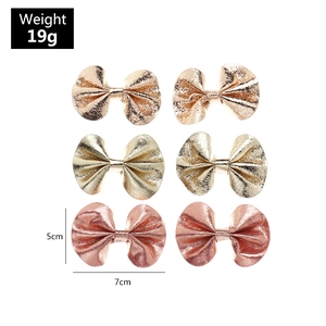 Detail showing 6-piece set of shiny faux leather bow hair clips in rose gold and pink colors