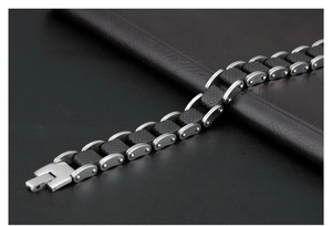 Detailed close-up of men's black silicone bracelet with silver steel and carbon fiber inlay