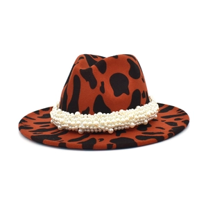Détail du chapeau fedora en laine avec motif vache et chaîne en perles blanches
