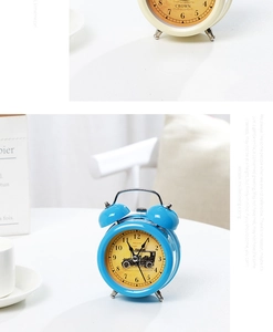 Detail of vintage metal alarm clocks in blue and beige with antique car dial designs