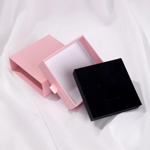 Pink drawer jewelry box with black sponge lining and silk ribbon handle on white satin