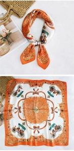 Detailed pattern of an orange equestrian silk scarf with horse carriage motifs and machine hem
