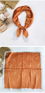 Detail of square silk scarf with orange feather print and smooth satin texture