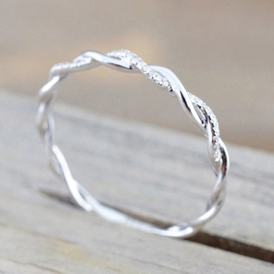 Silver twisted rope ring with pave set diamonds on light wood background