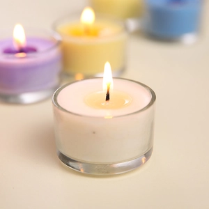 Romantic scented candle in glass cup with warm flame for Valentines Day and proposal decor