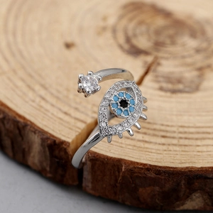 Vista macro de anillo ajustable ojo turco plateado con circón azul sobre madera
